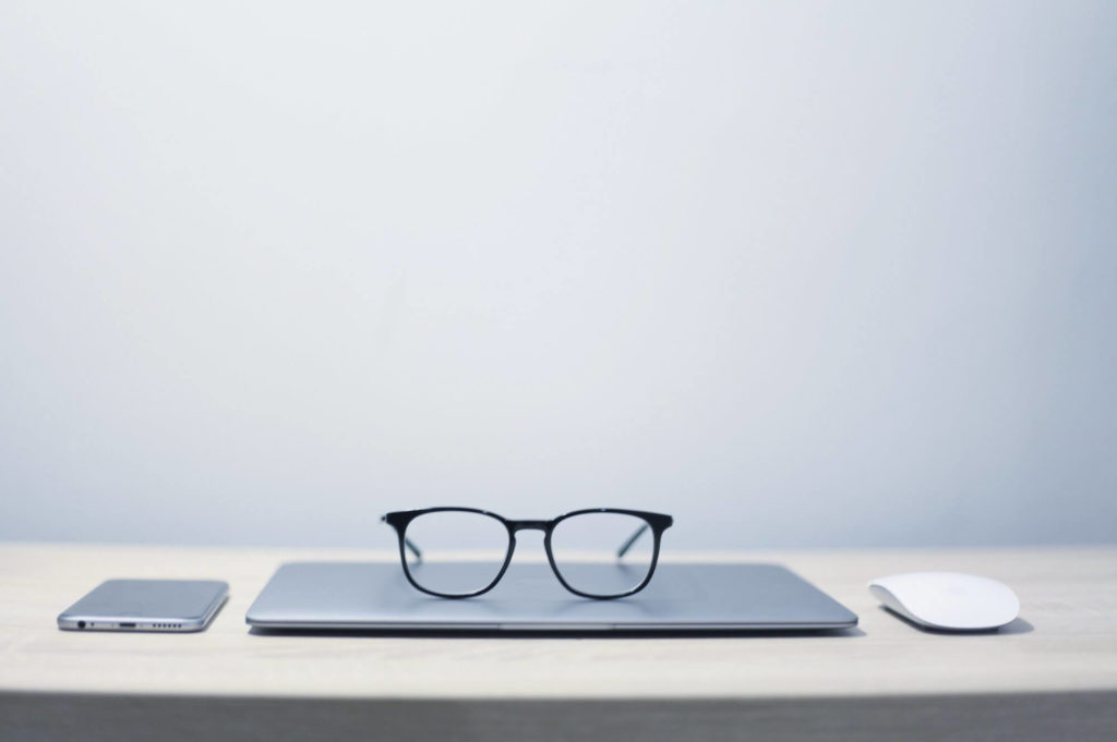 laptop and glasses to see more visually appealing thing sitting on table, to symbolize  using images that increase traffic to your blog