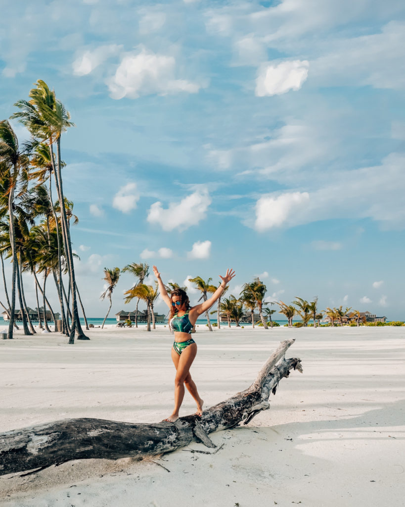 Isabella walking on a tree on a beach in The Maldives