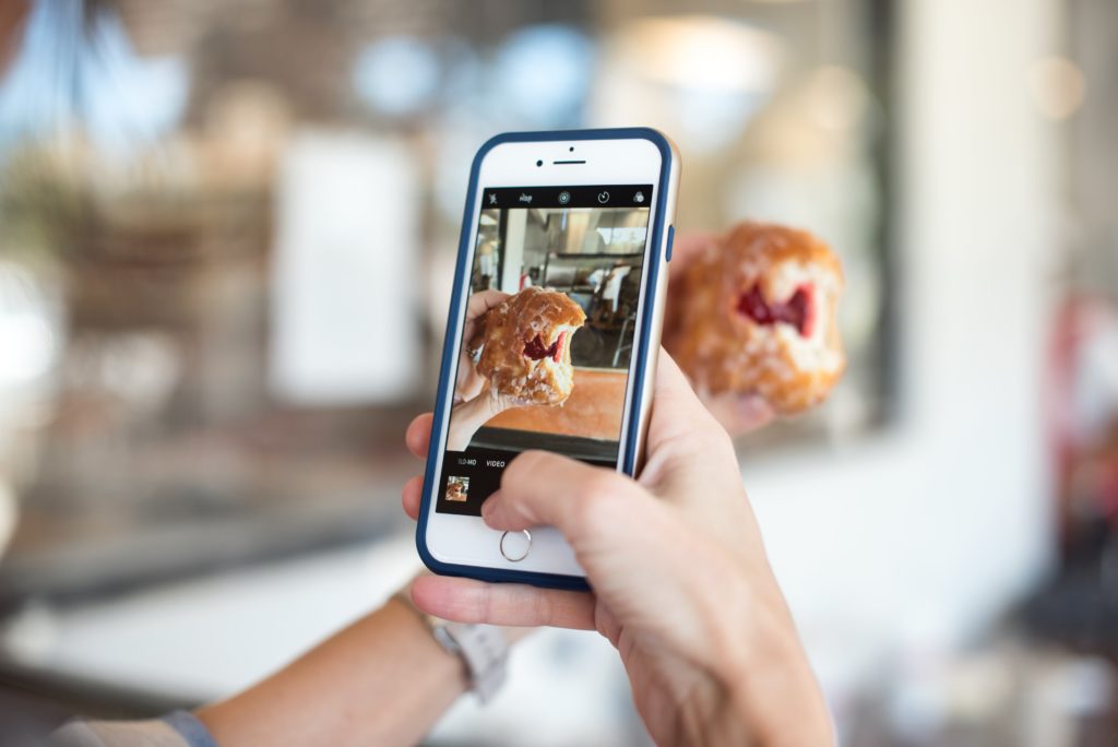 iPhone user taking a photo of a donut