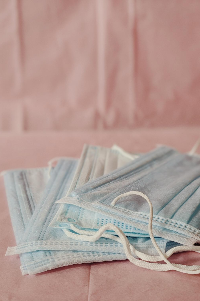 Surgical masks against a pink background