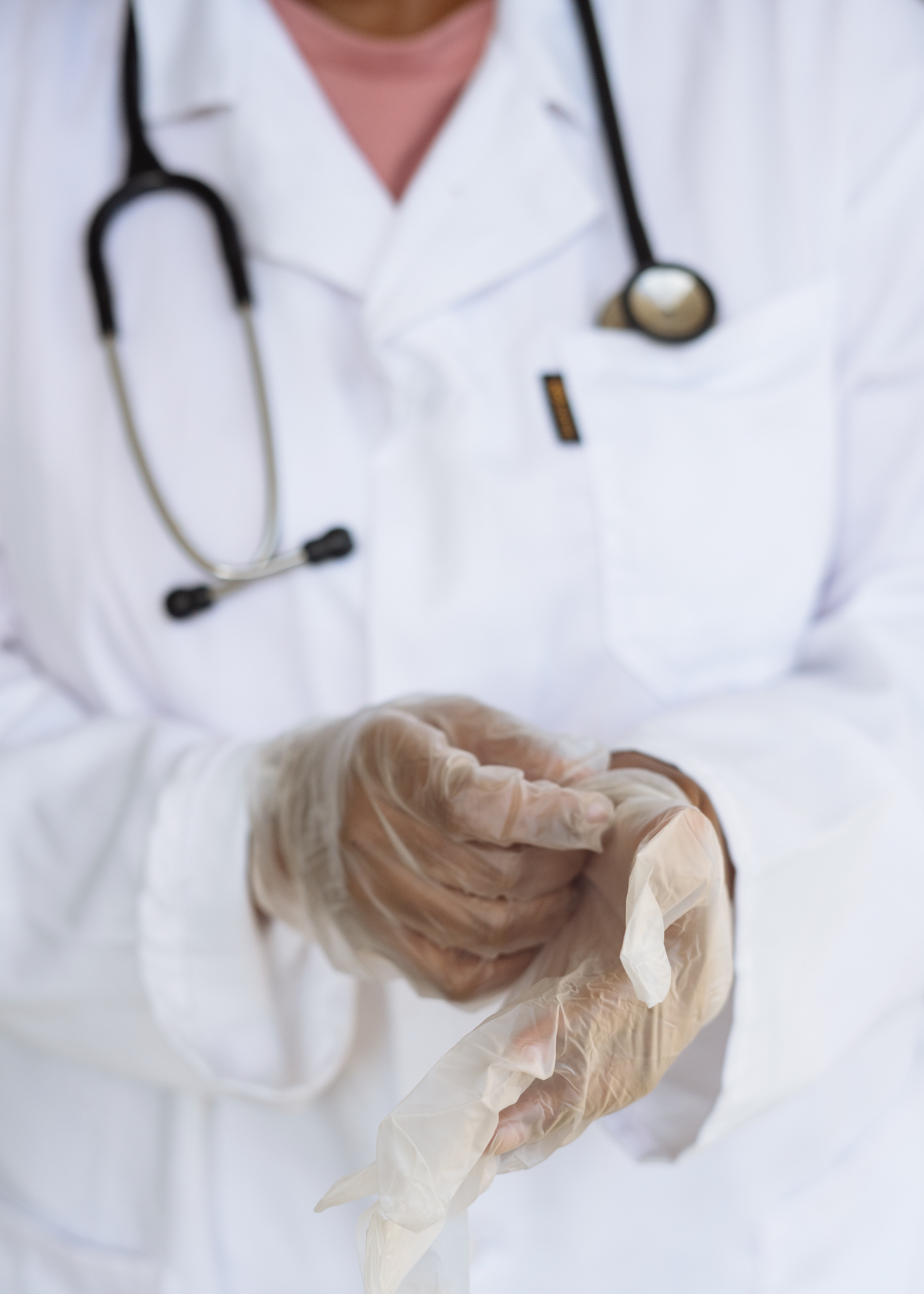 doctor in white coat pulling on gloves