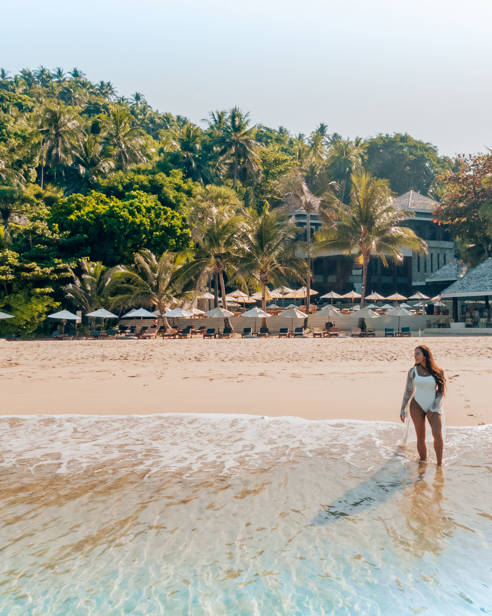 Isabella standing on the beach in Phuket in front of the Surin resort