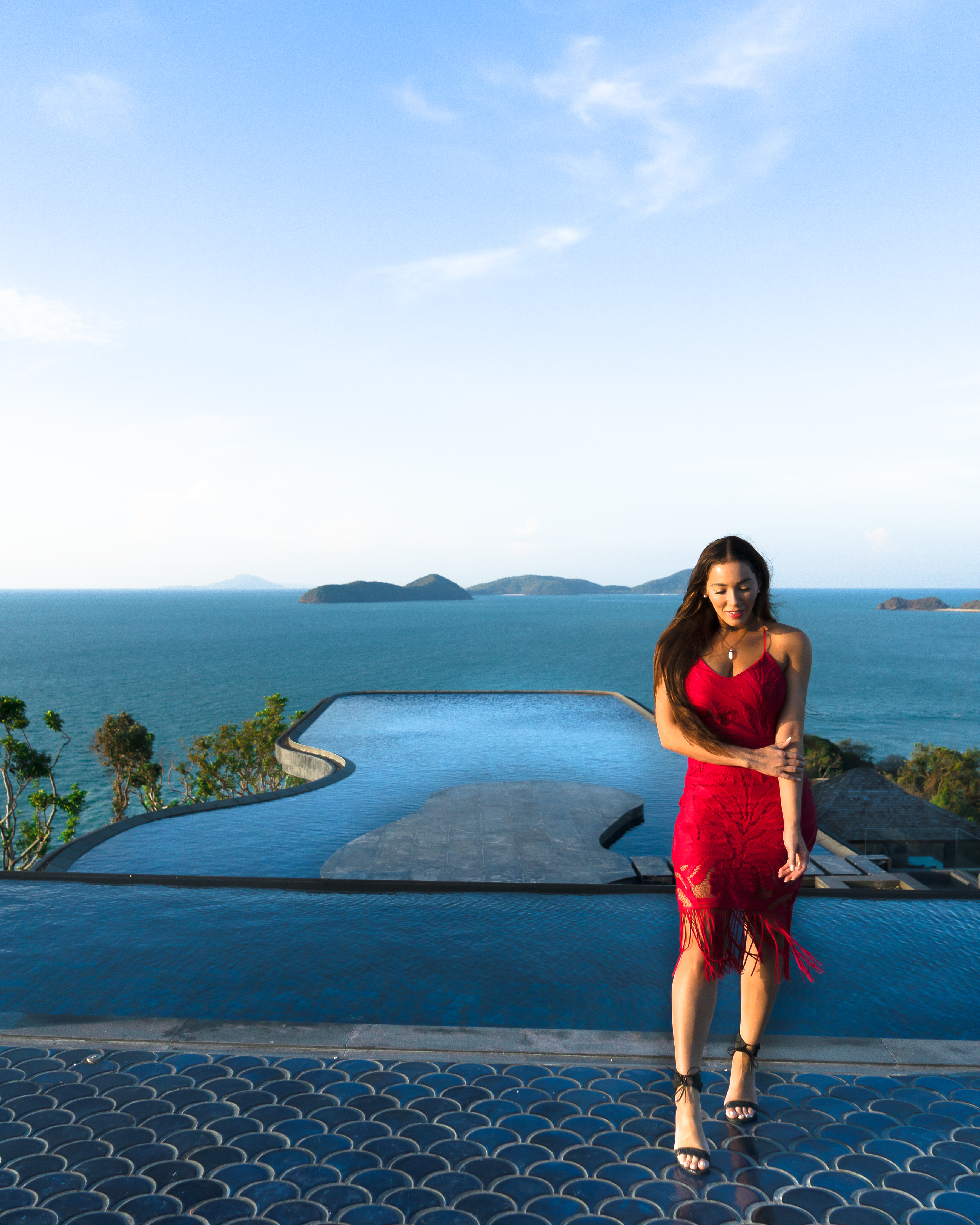 Isabella standing in front of an infinity pool at Baba's Nest in Thailand