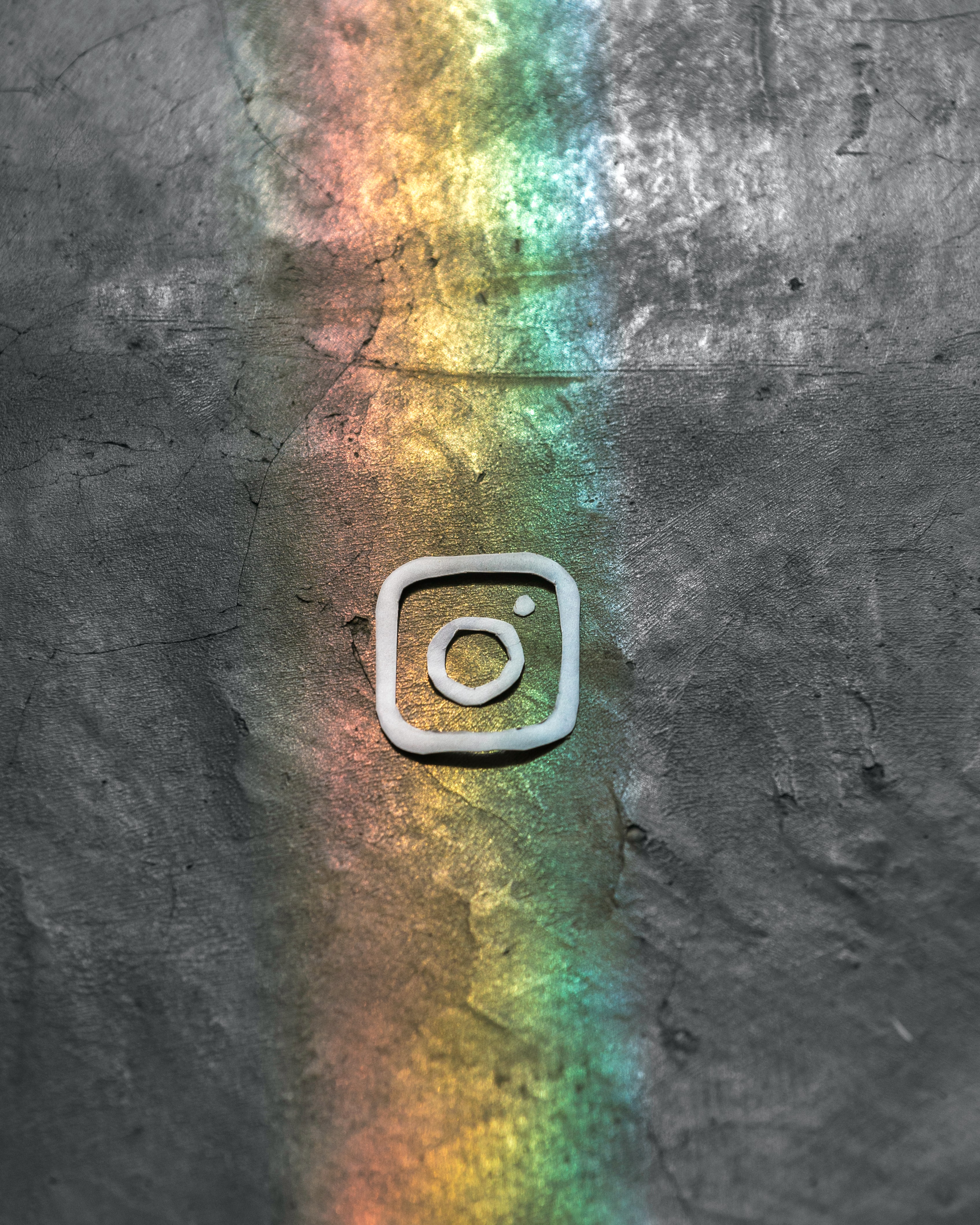 Instagram logo on grey background with rainbow light