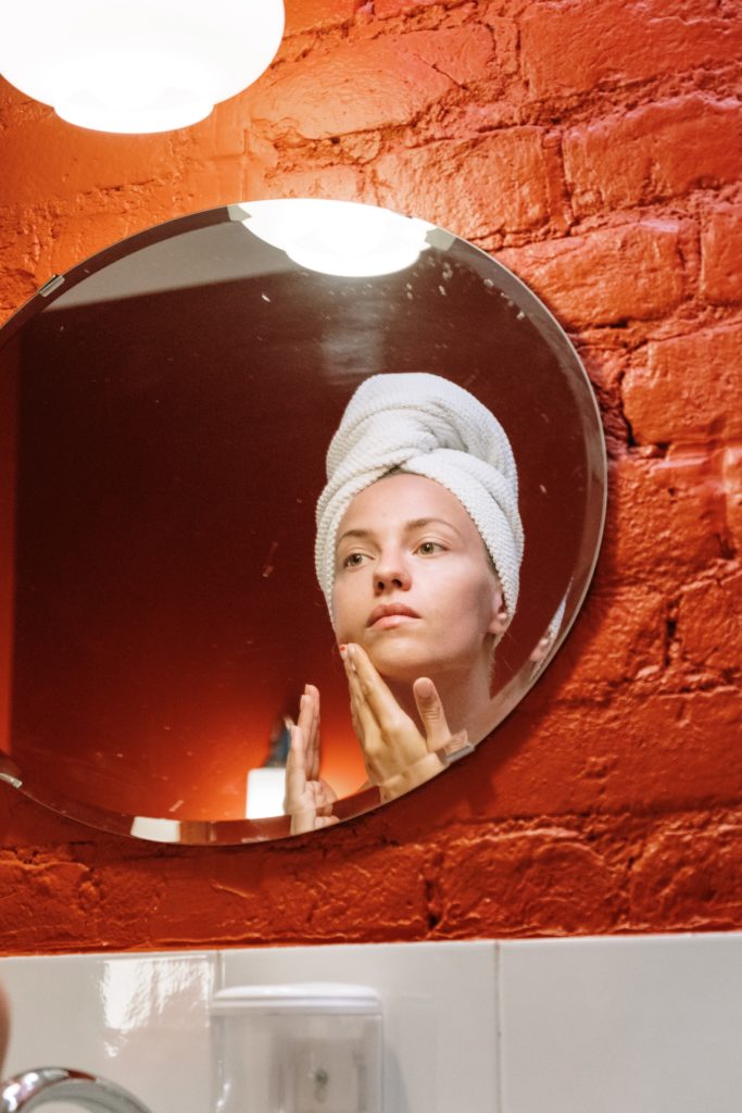 A woman looking at her reflection in the mirror 