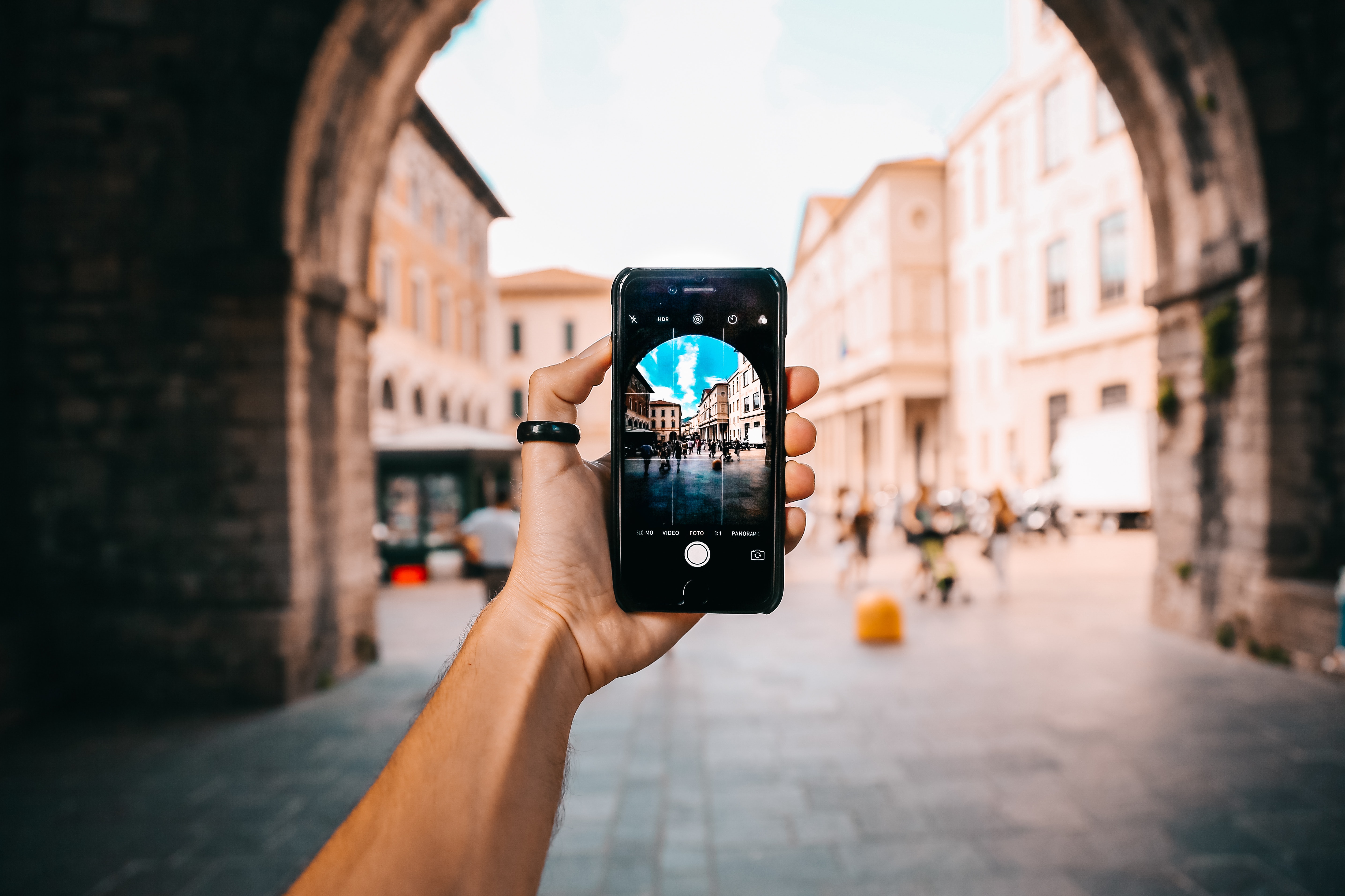 Hand holding a phone up in front of an archway