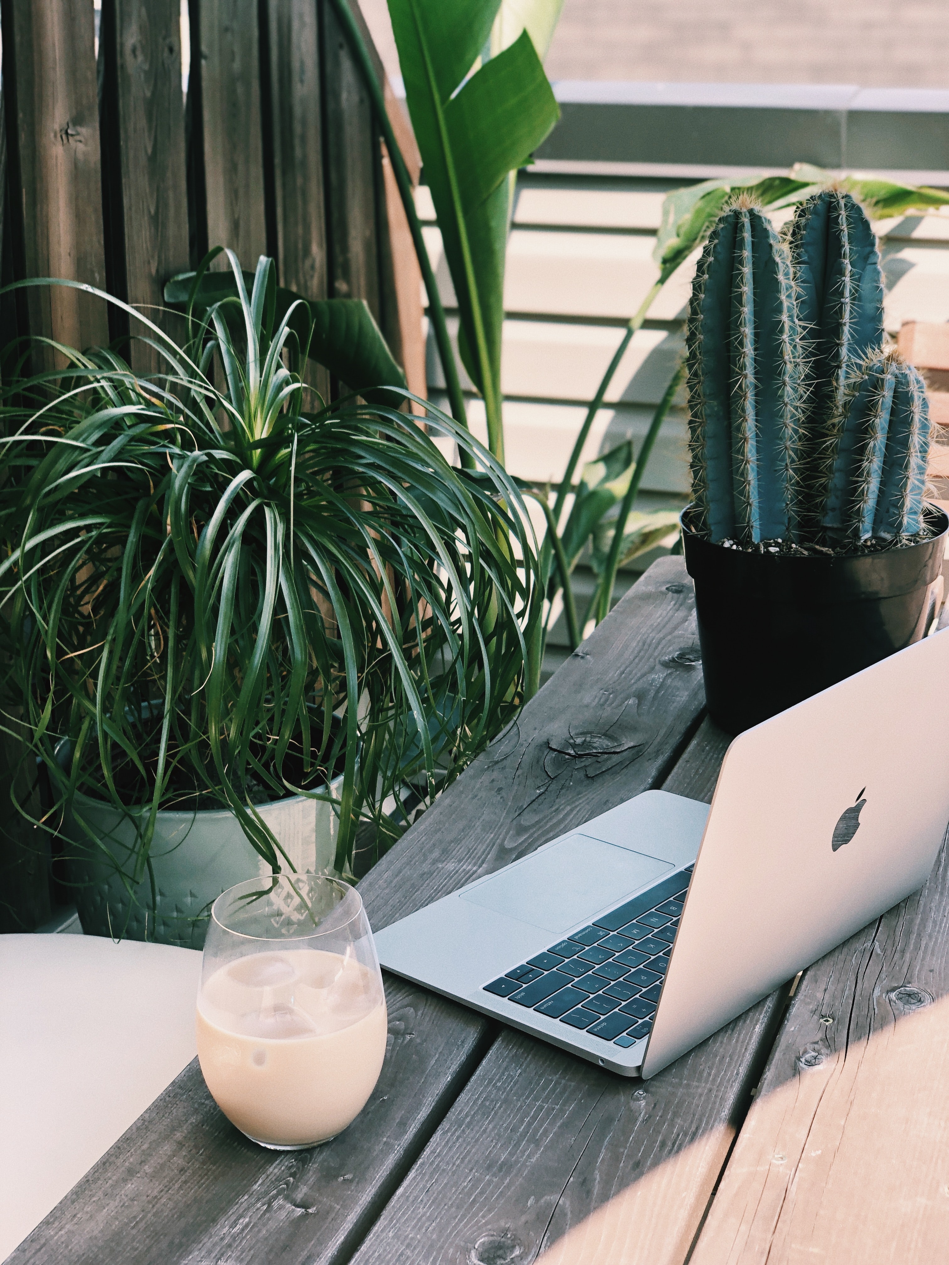 A laptop and smoothie on a wooden table