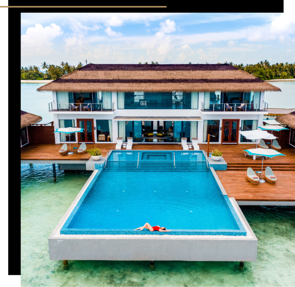 Isabella in a red suit laying on the edge of the pool at an overwater villa at the Pullman Maldives