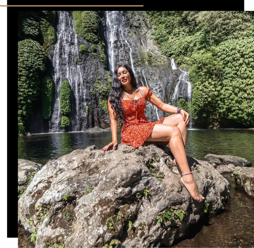 Isabella sitting on top of a rock at a waterfall 