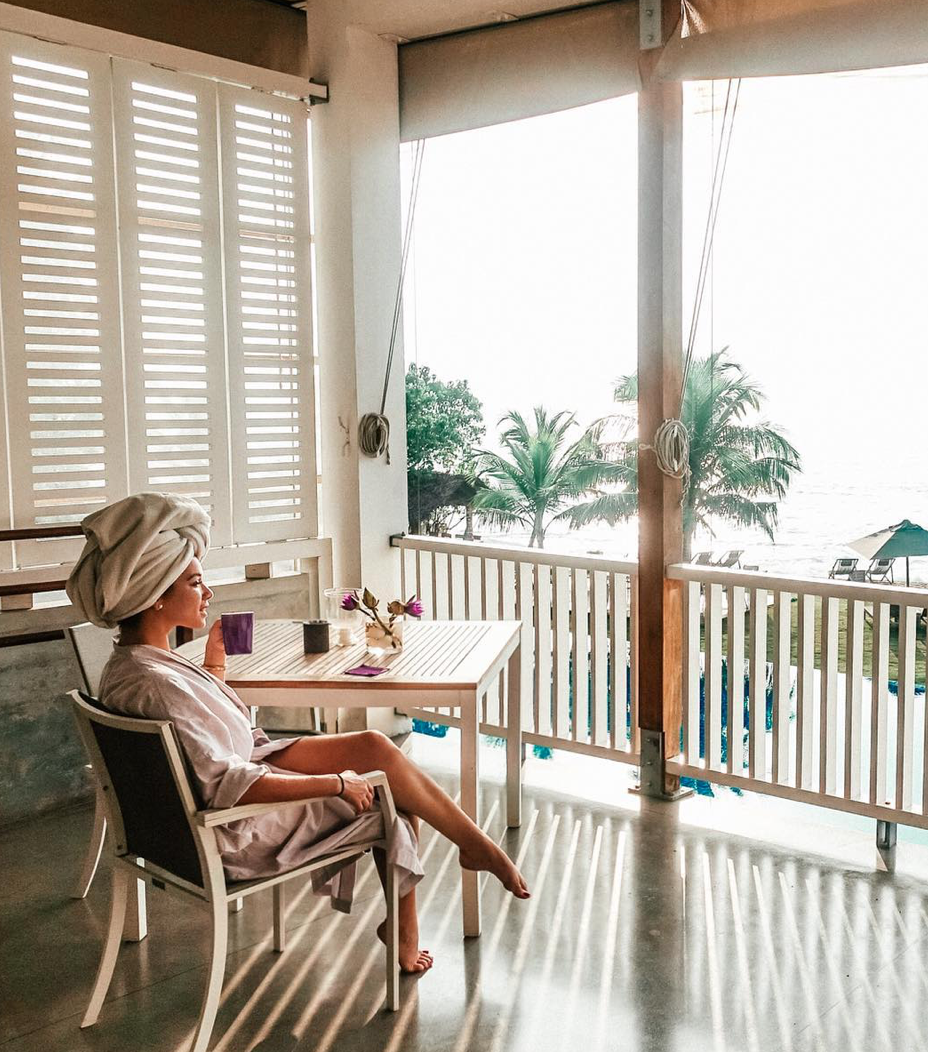 Isabella sitting on the veranda with a cup of tea