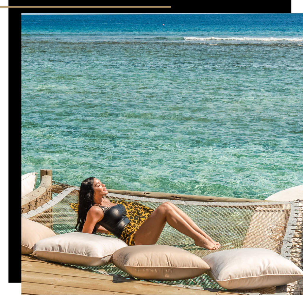 Isabella laying on an overwater hammock at Soneva Fushi