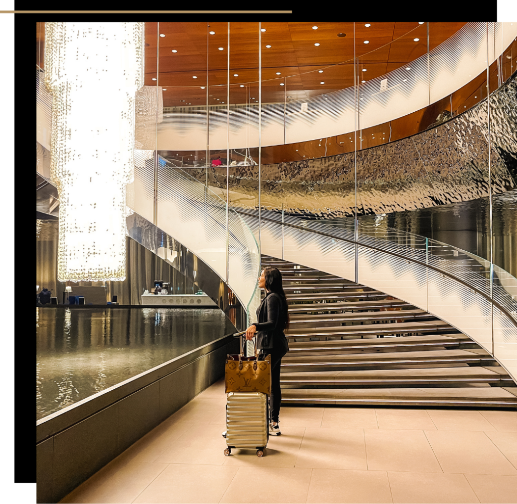 Isabella with luggage by the staircase of the Al Mourjan Business Lounge 